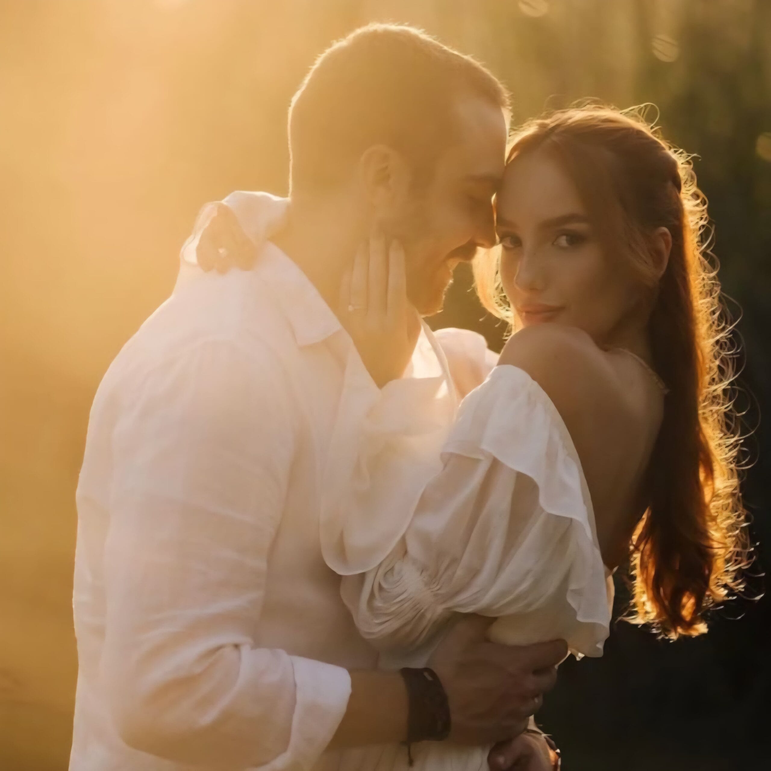 Pareja de novios abrazándose tiernamente con la luz cálida del atardecer detrás, en una fotografía de bodas romántica en Uruguay.